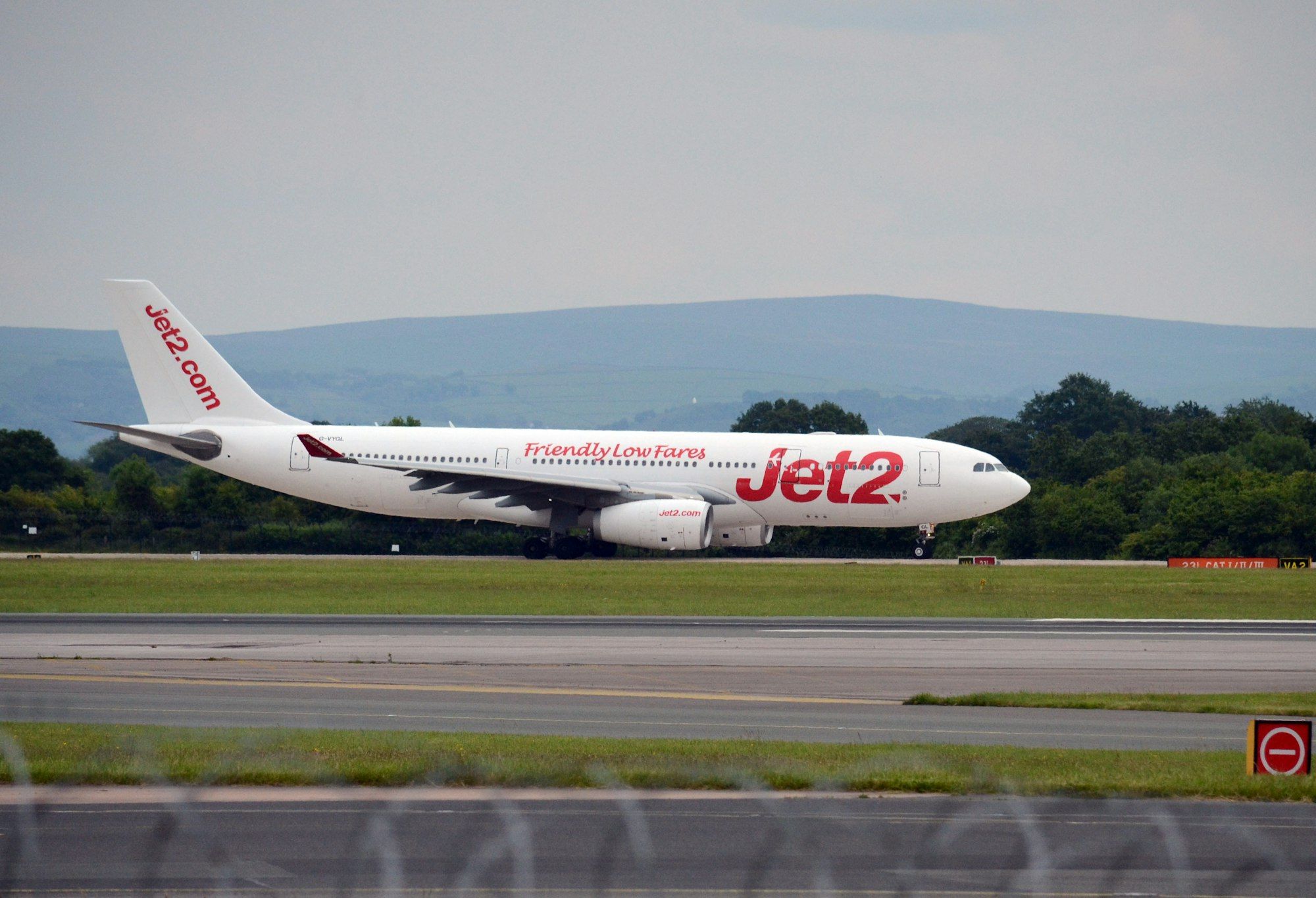A Jet2 airline aircraft is seen on the runway, preparing for takeoff. The plane features a distinctive livery with the company branding prominently displayed.