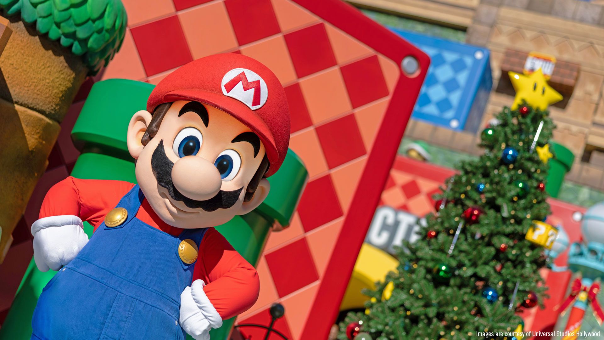 A large, animated character resembling a classic video game plumber stands in front of colorful decorations. The scene features a backdrop of festive elements, suggesting a themed celebration or event.