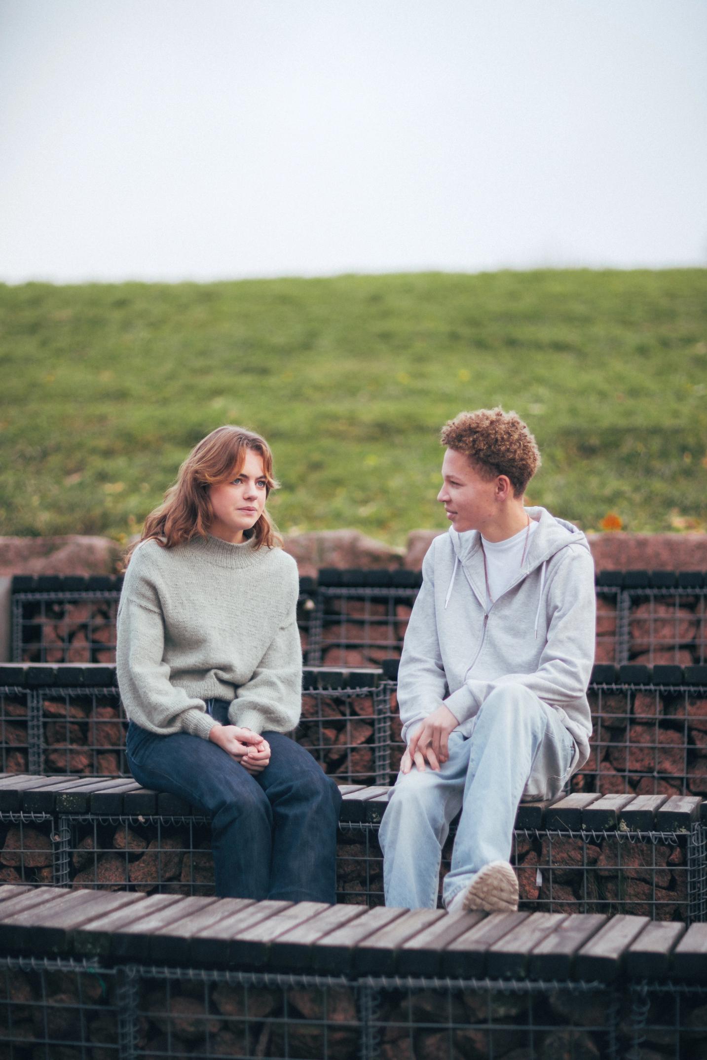 To personer som snakker sammen sittende utendørs