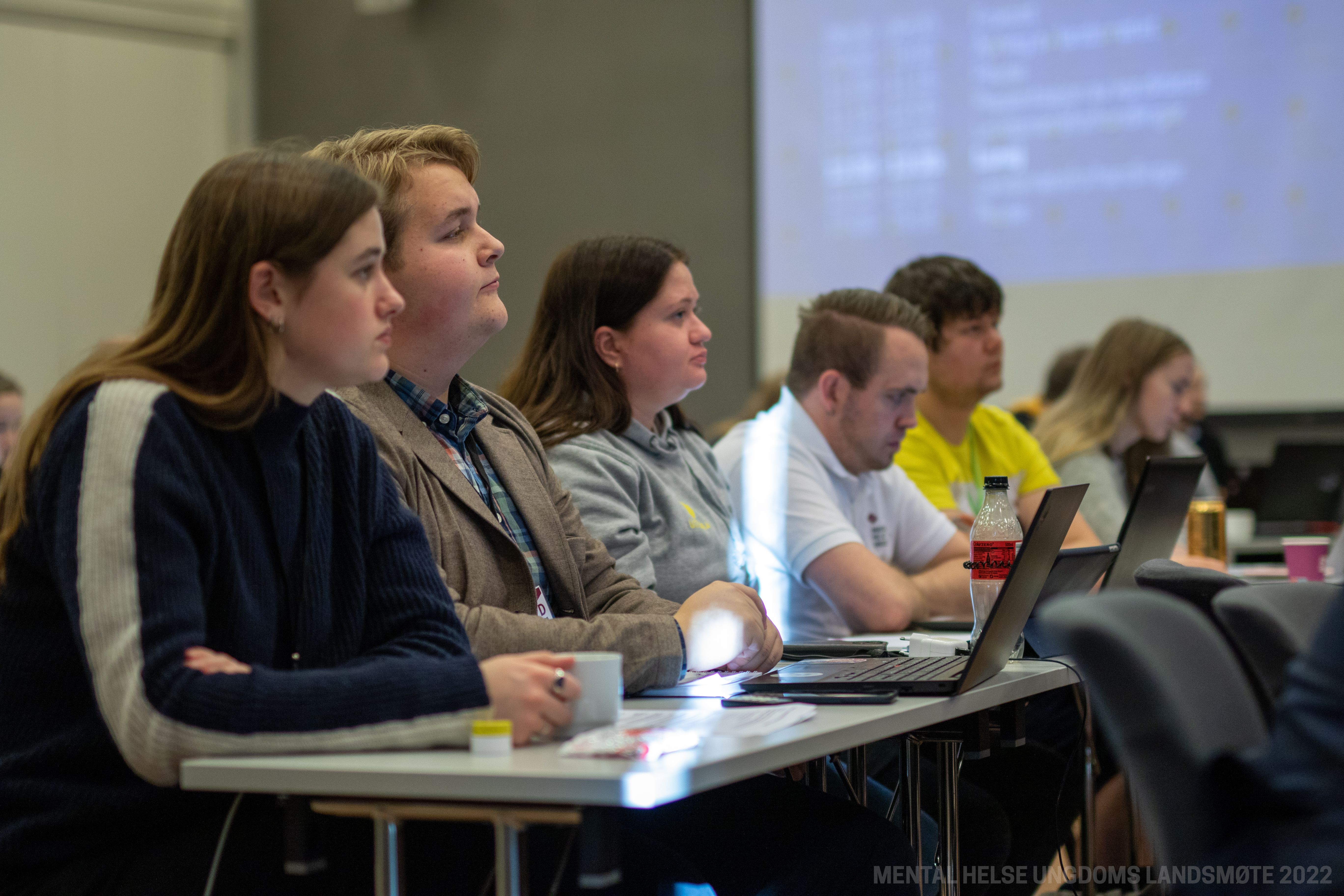 Ungdommer sitter i en landsmøtesal