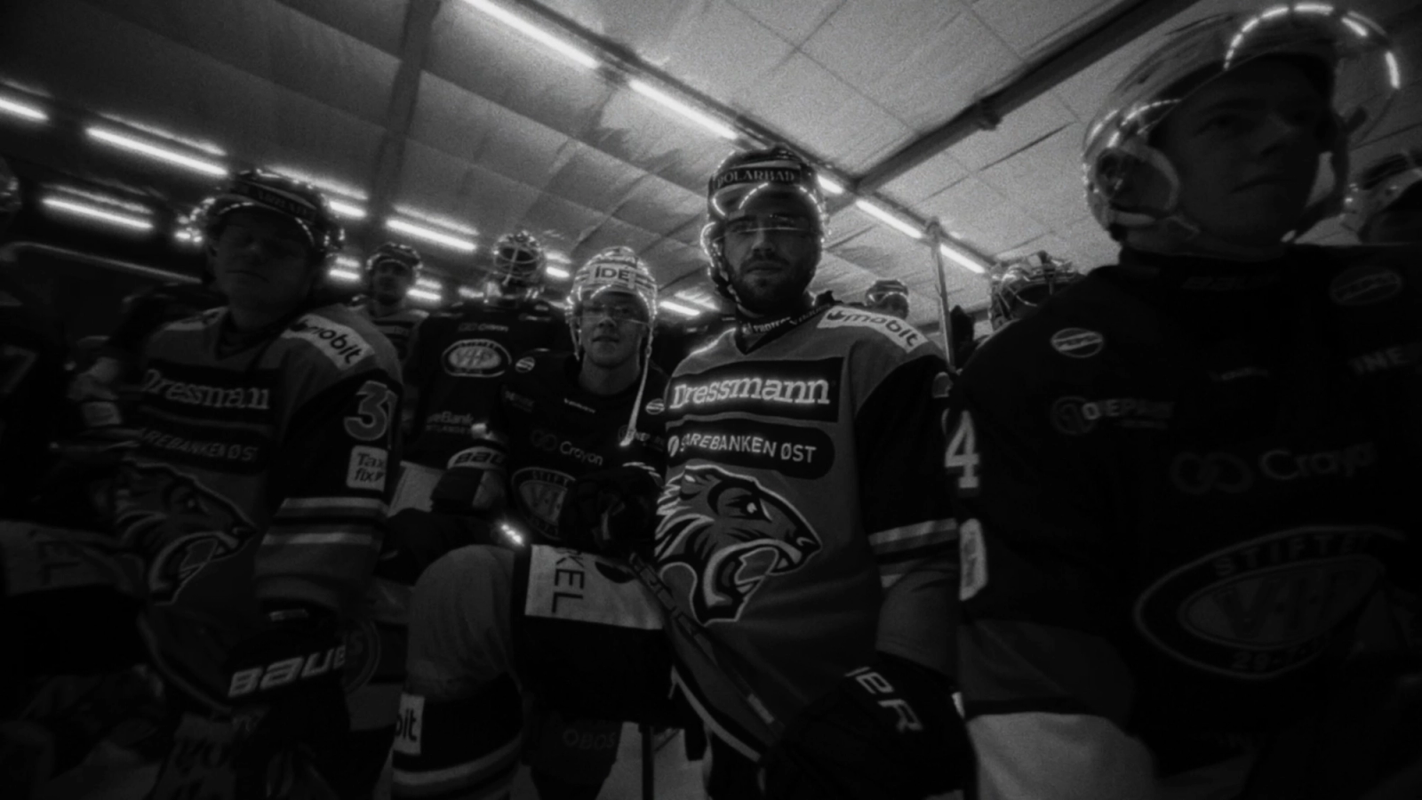 Flere hockey-spillere som står samlet, som ser inn i kamera