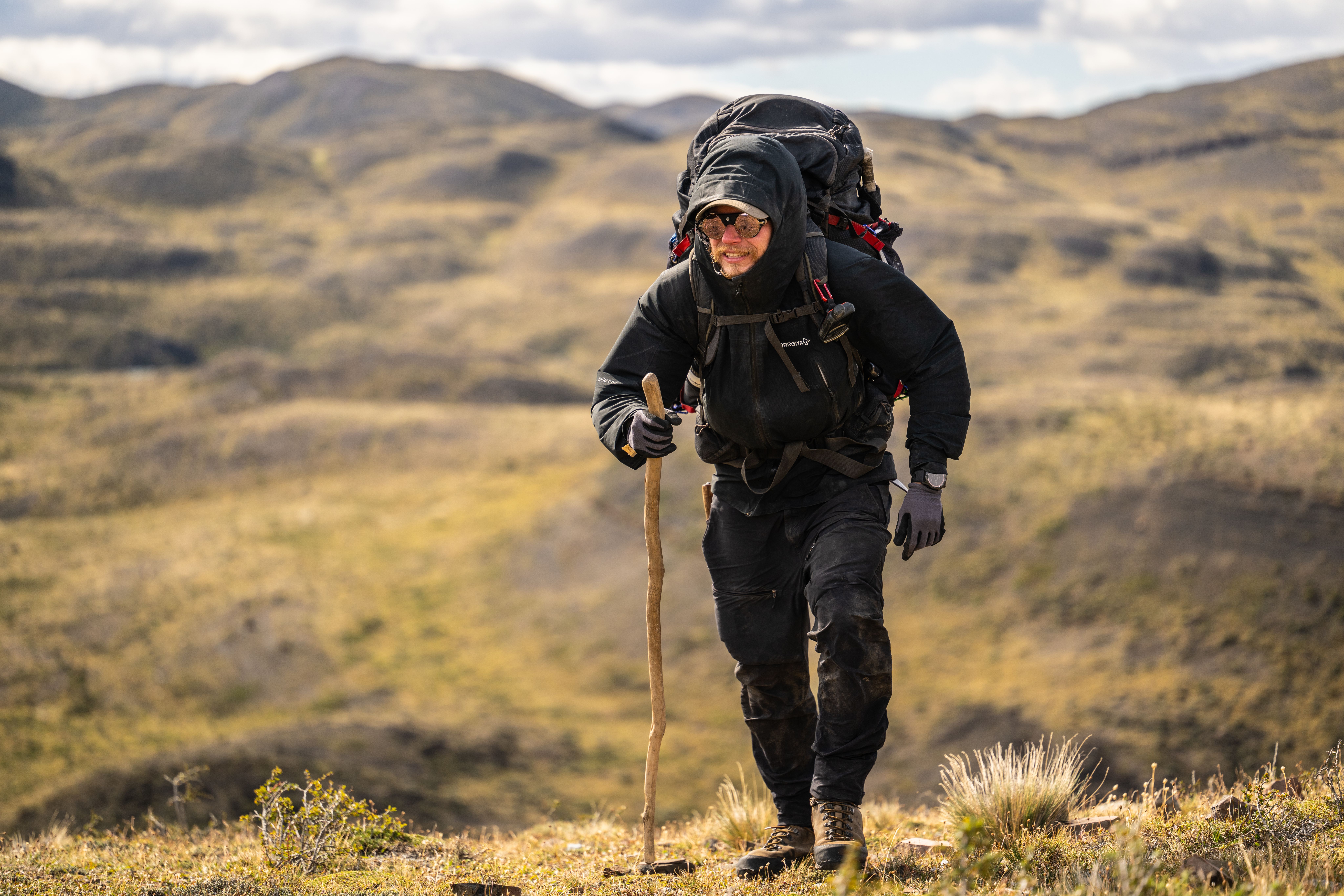 Fredrik som går på vidde med full oppakning og stokk