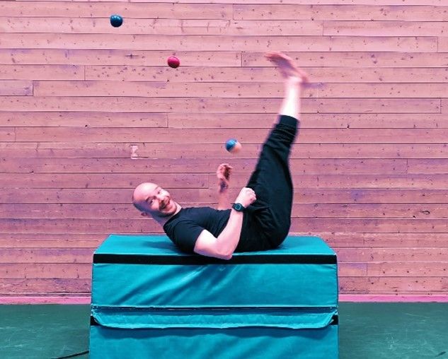 Verkstedleder sirkuslek, Janne, som sjonglerer liggende