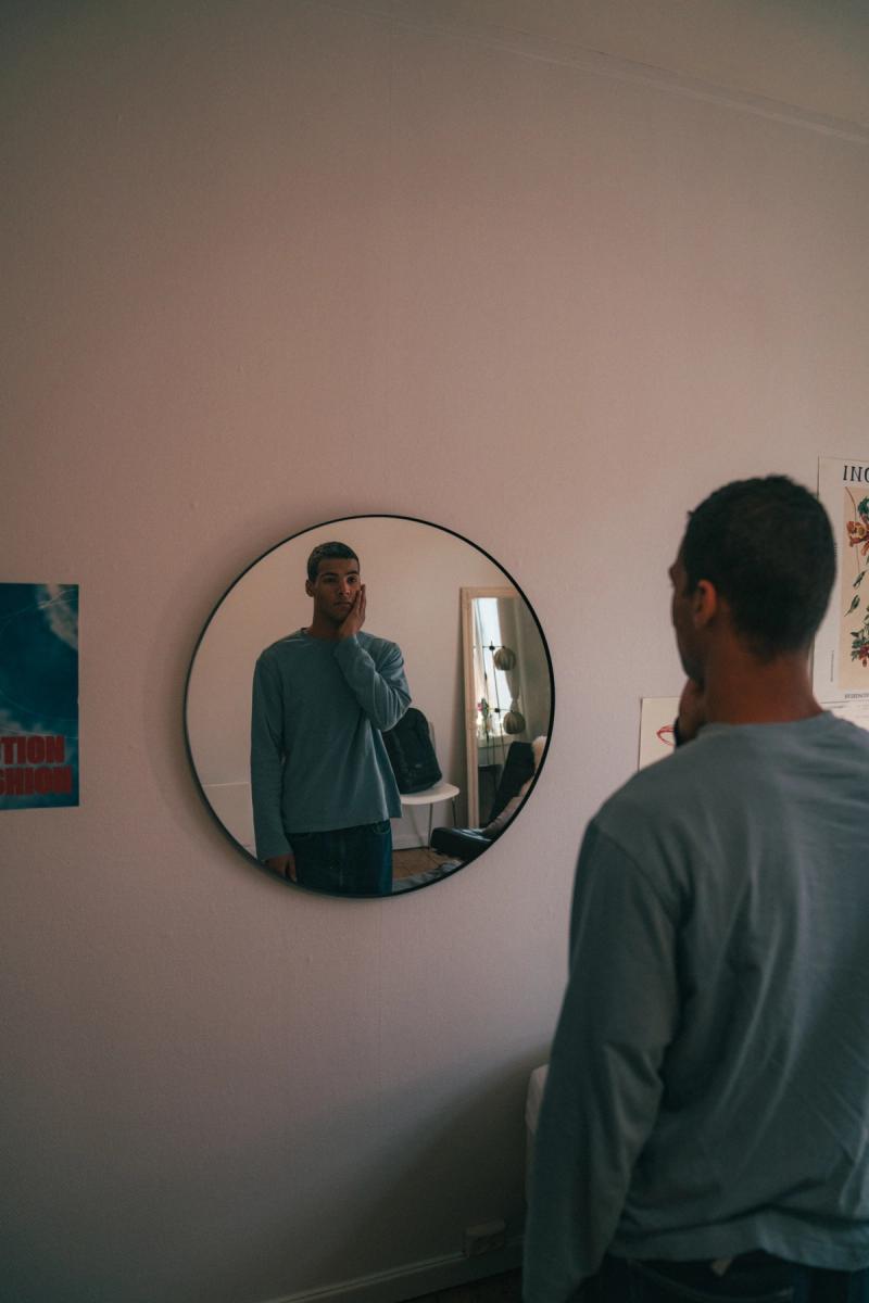 gutt ser seg i speilet