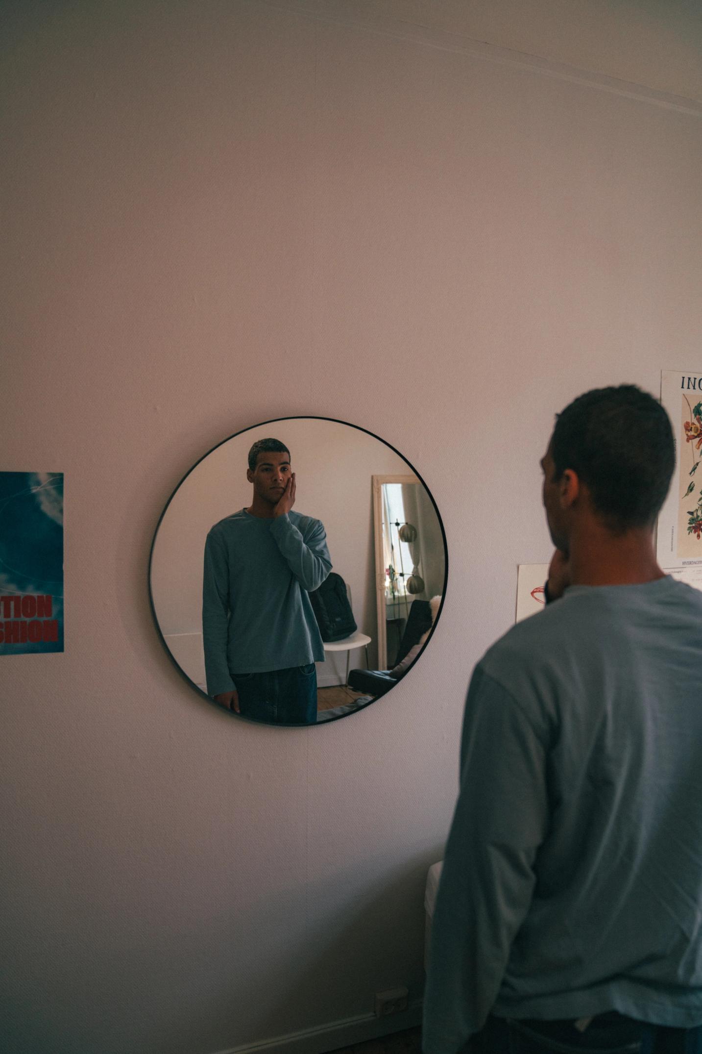 Ung mann ser på seg selv i speilet