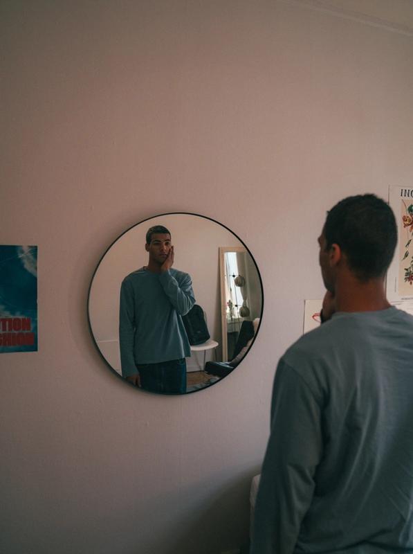 Ung mann ser på seg selv i speilet