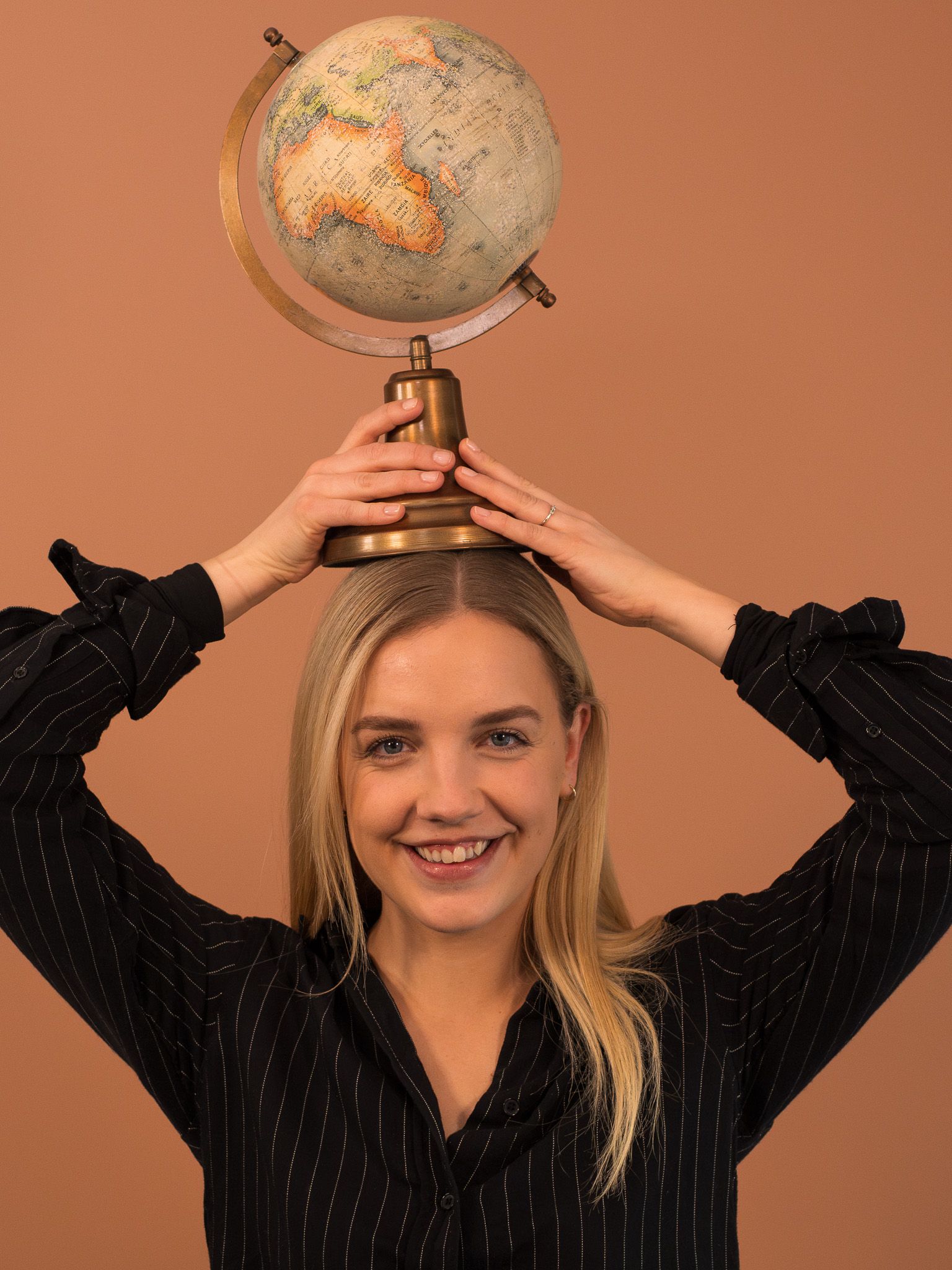 Uformelt bilde av Celine hvor hun holder en globus over hodet