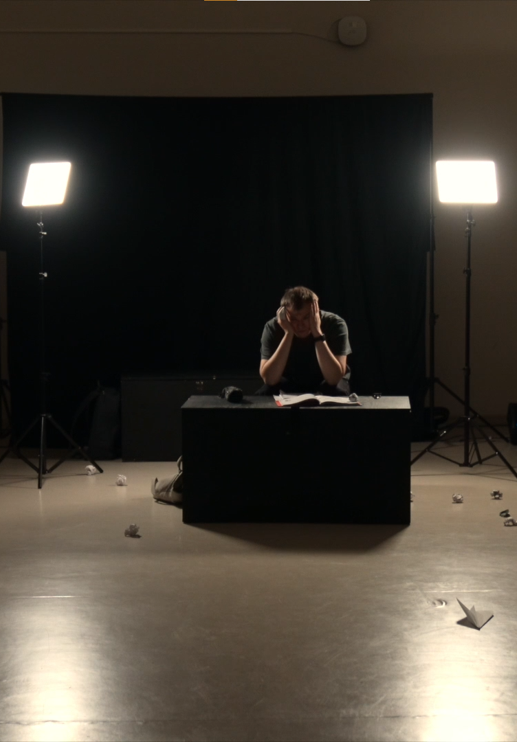 Bilde fra forestillingen - ung mann med lyskastere på seg