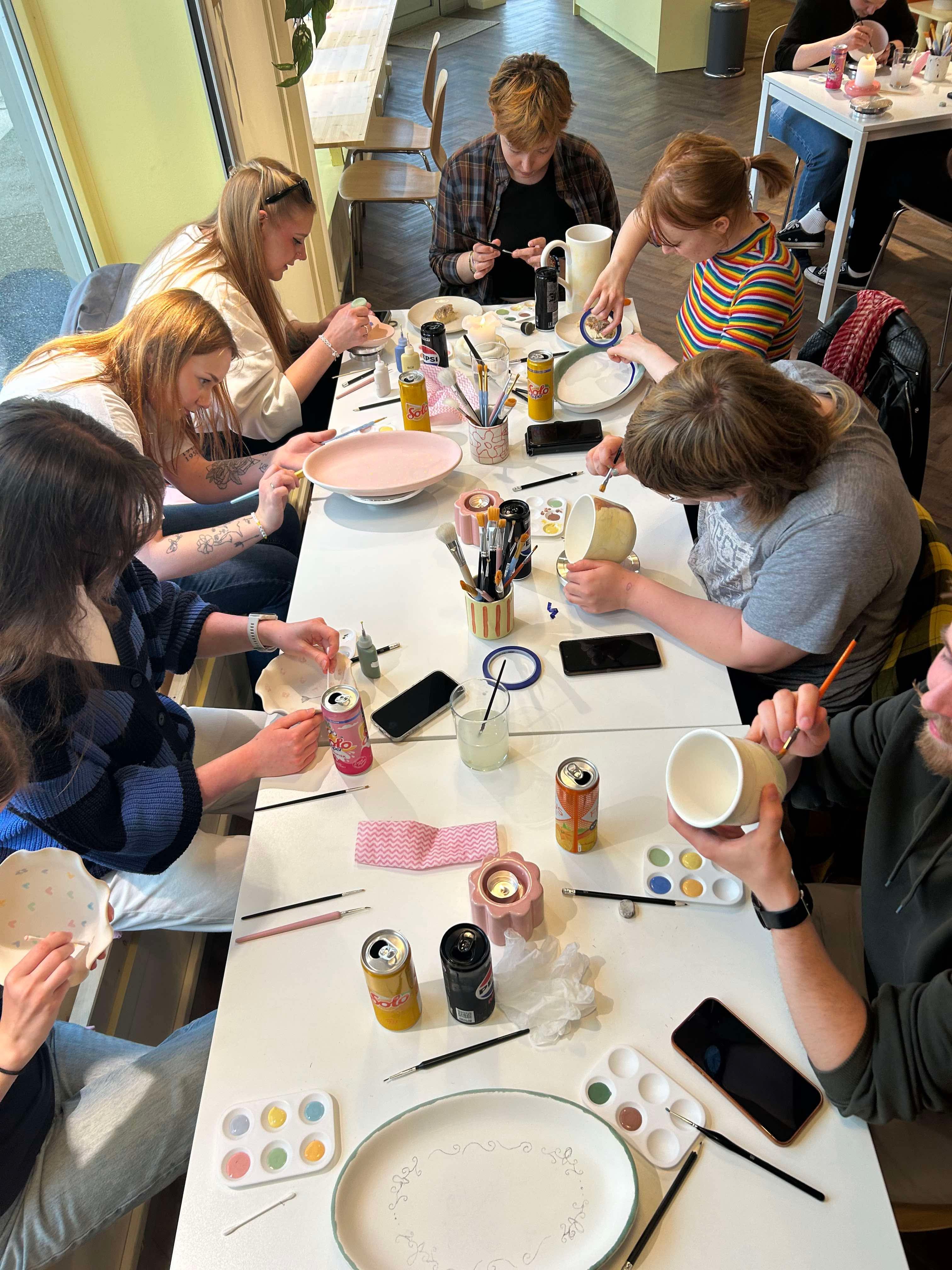 Bilde av medlemmer fra MHU Sotra som maler på vaser.