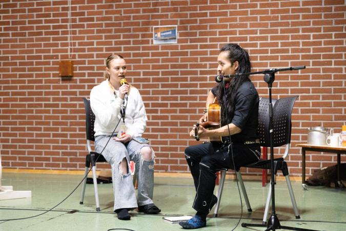 En person med mikrofon og en person med gitar