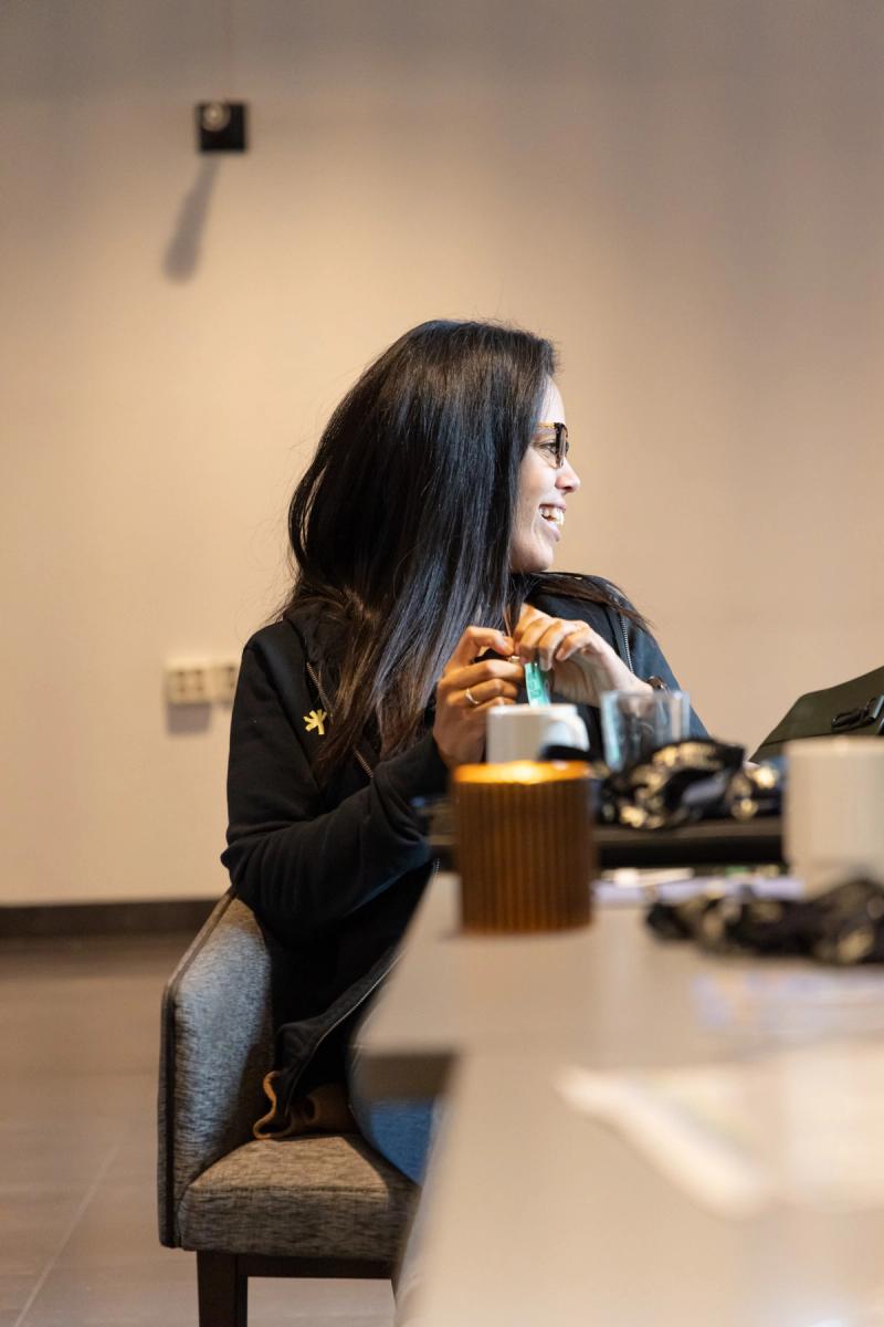 Kvinne som ser til siden og ler.