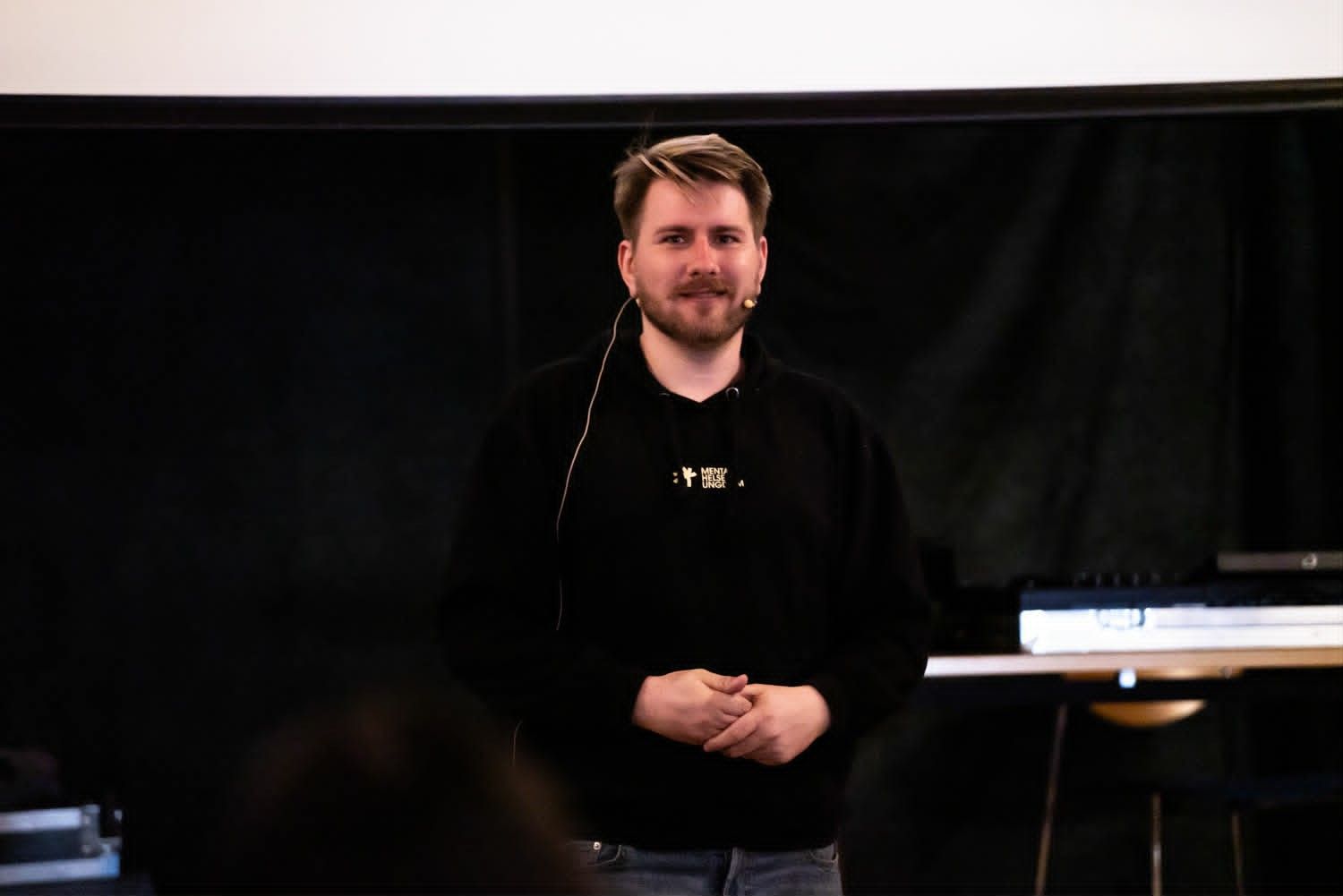 Christoffer som står på en scene og holder foredrag
