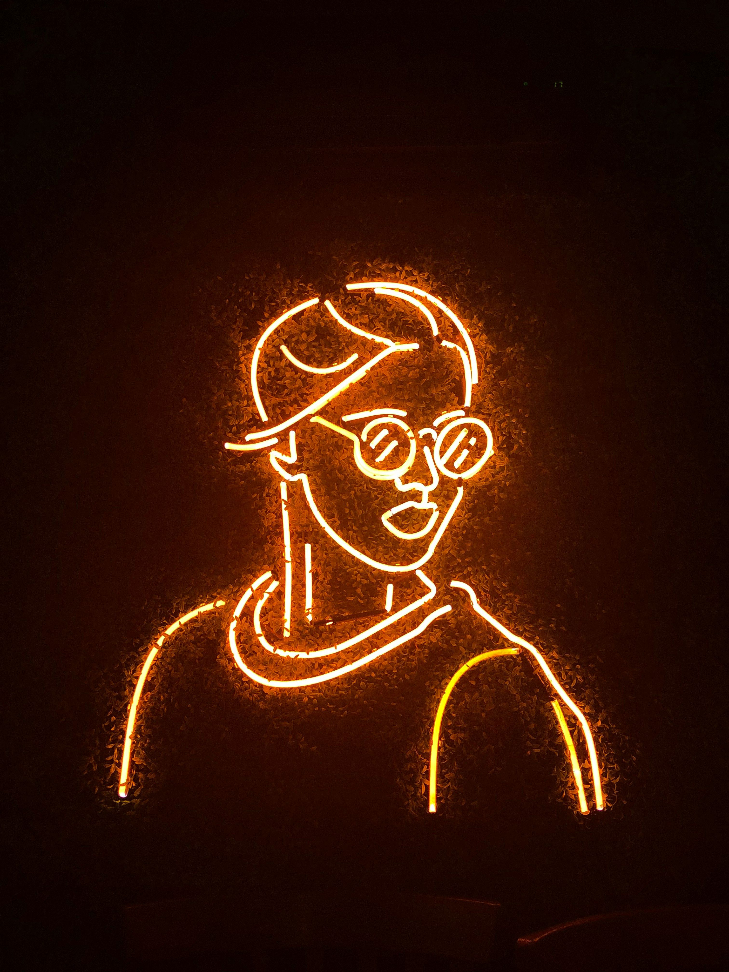 Neon skilt som avbilder en person med briller