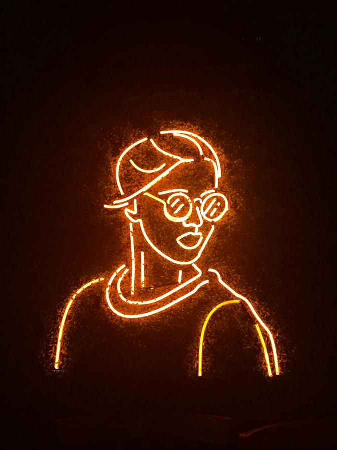 Neon skilt som avbilder en person med briller