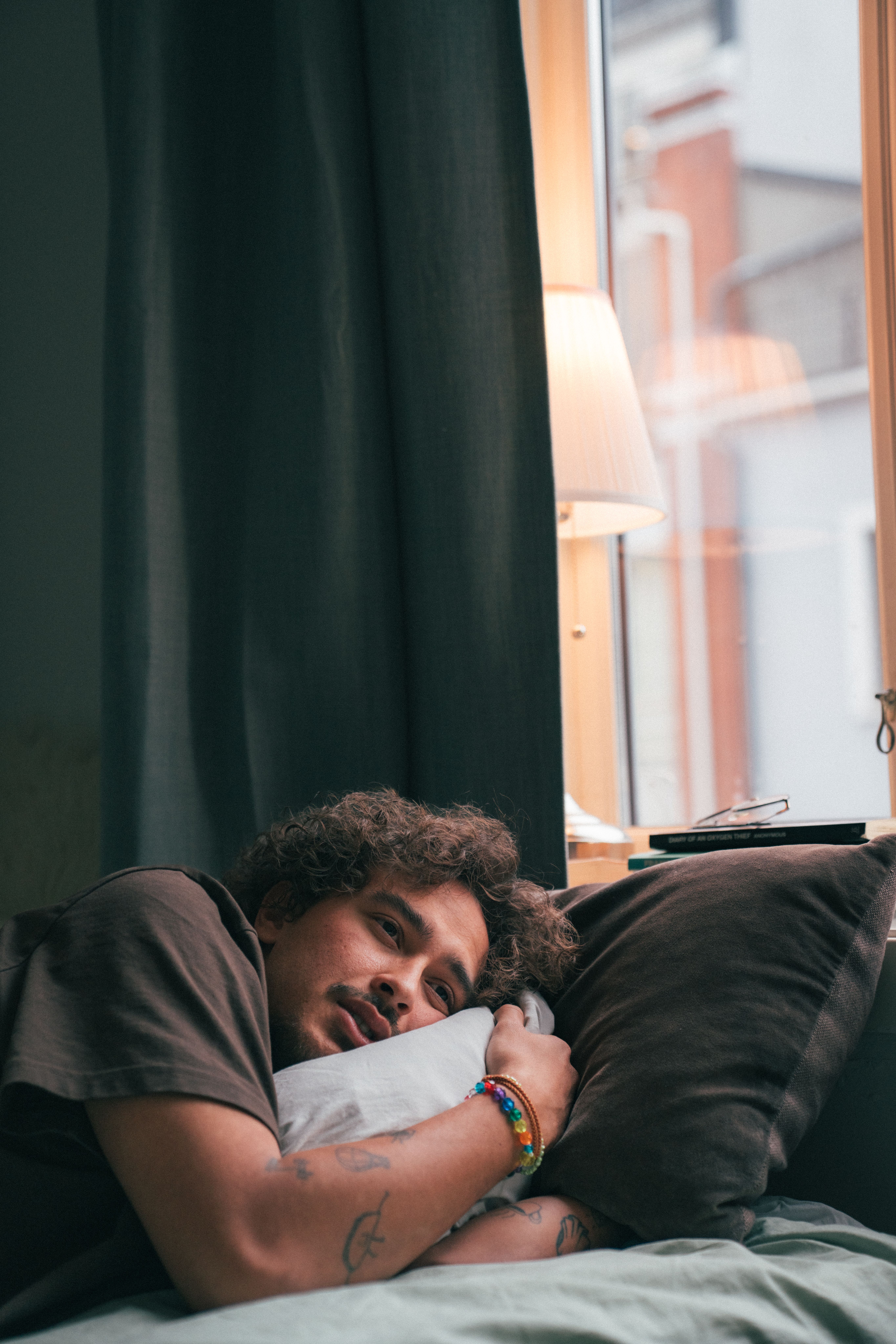 Ung mann ligger i sengen og ser ut i luften