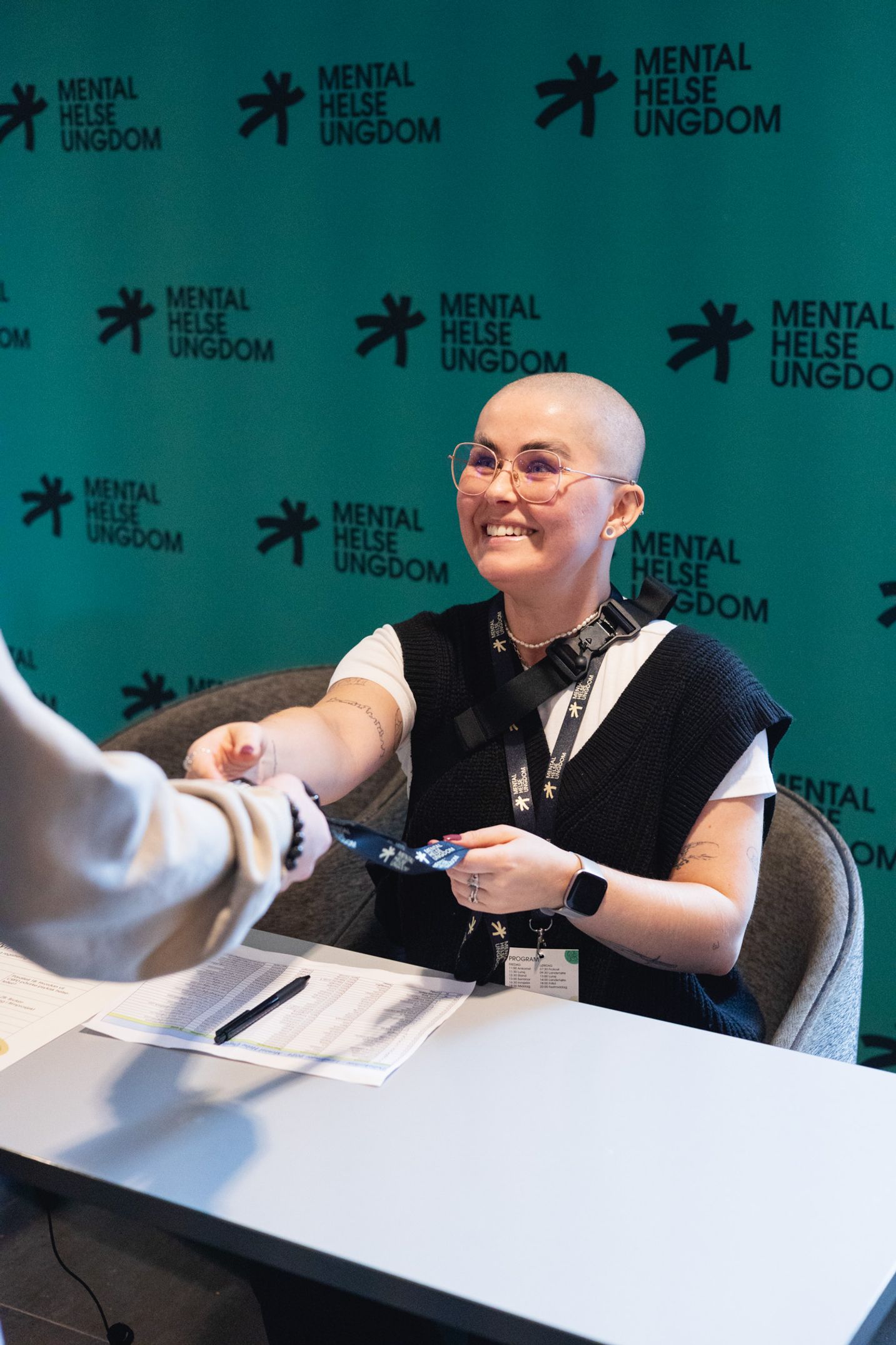 En person som gir en annen person et navnekort på et event