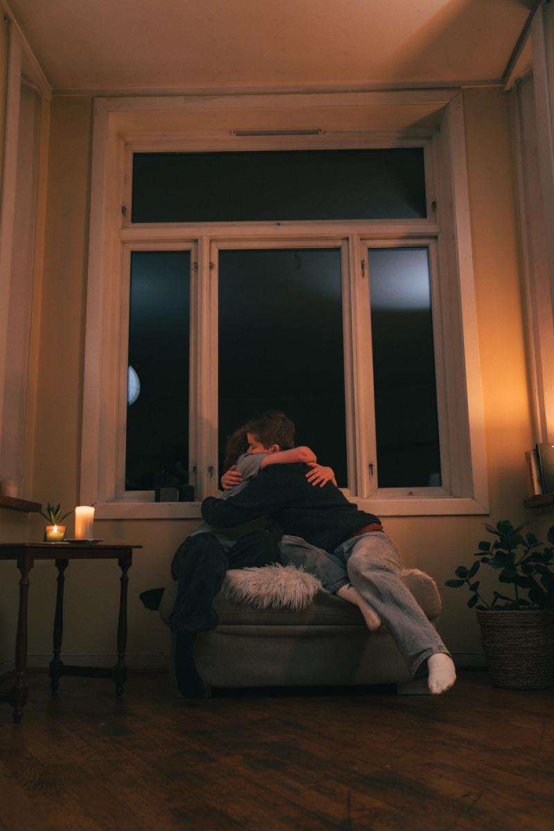 Jente og gutta i sofa klemmer