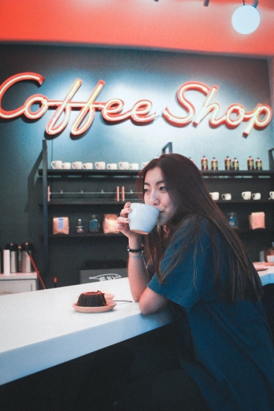 Girl Enjoys Coffee at a Coffee Shop