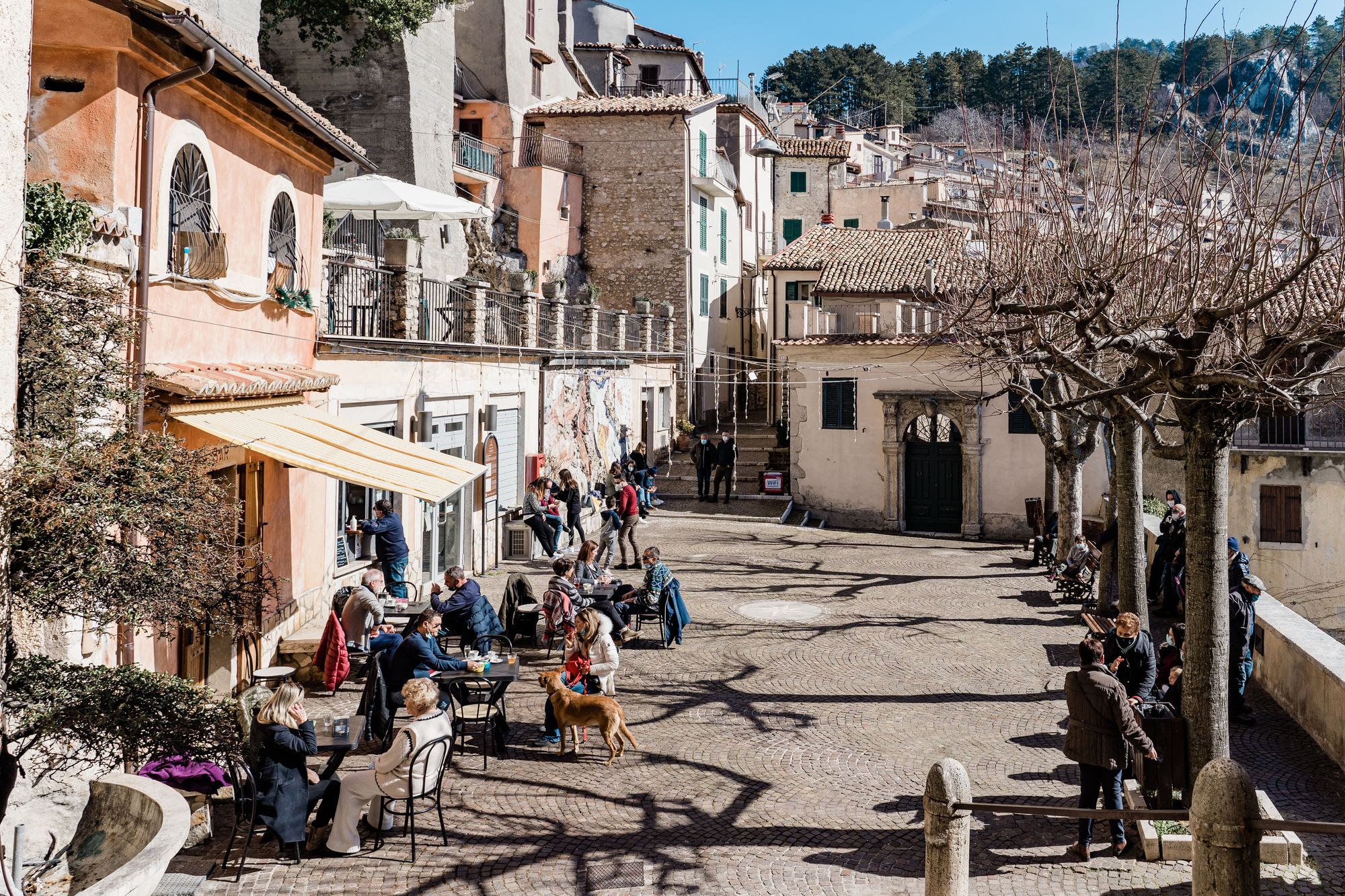 People enjoying coffee in the sun at the piazza in Cervara di Roma, Lazio, Italy