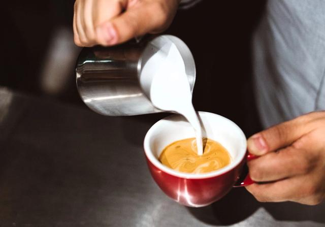 Pouring Steamed Milk into Cup of Espresso