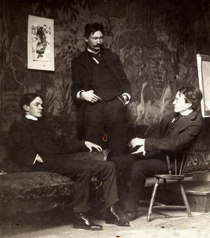 a black and white photo of three men sitting on a couch