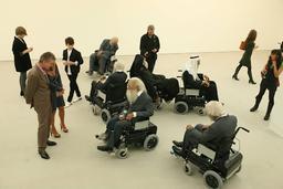 a group of people are sitting in wheelchairs in a room .