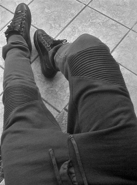 a black and white photo of a person 's legs and shoes