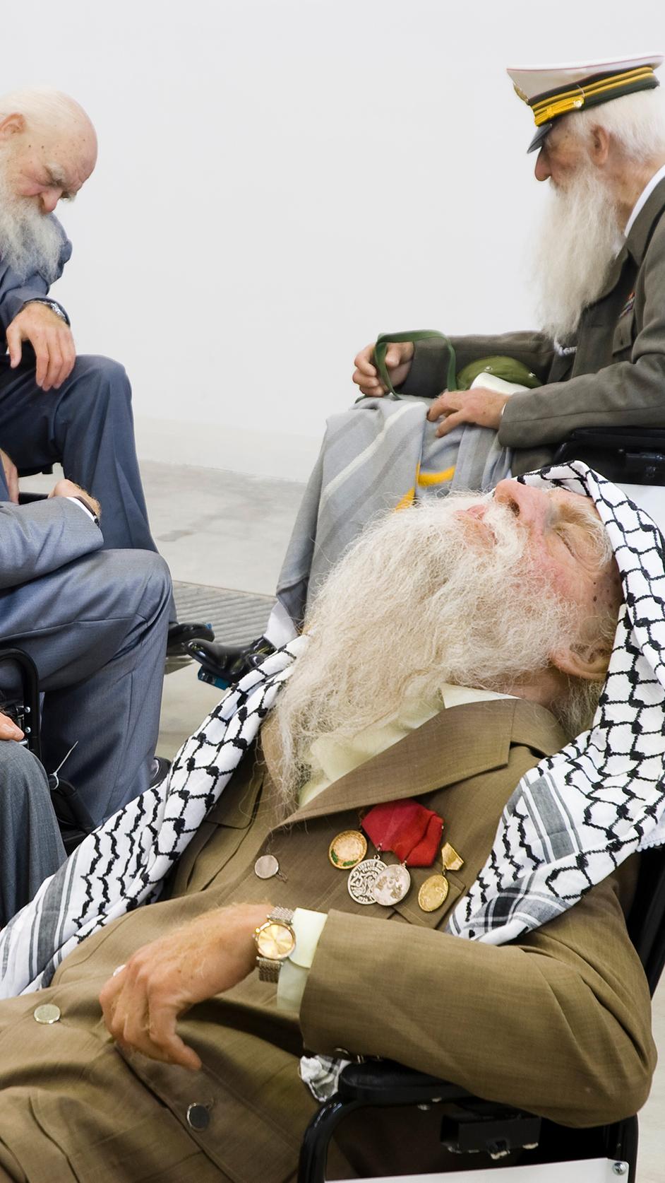 a group of elderly men with beards are sitting in wheelchairs .