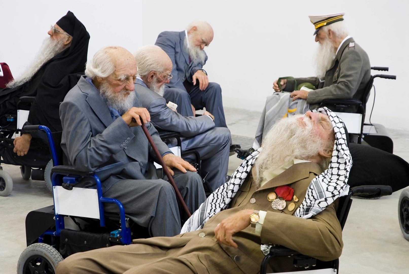 a group of elderly men with beards are sitting in wheelchairs .