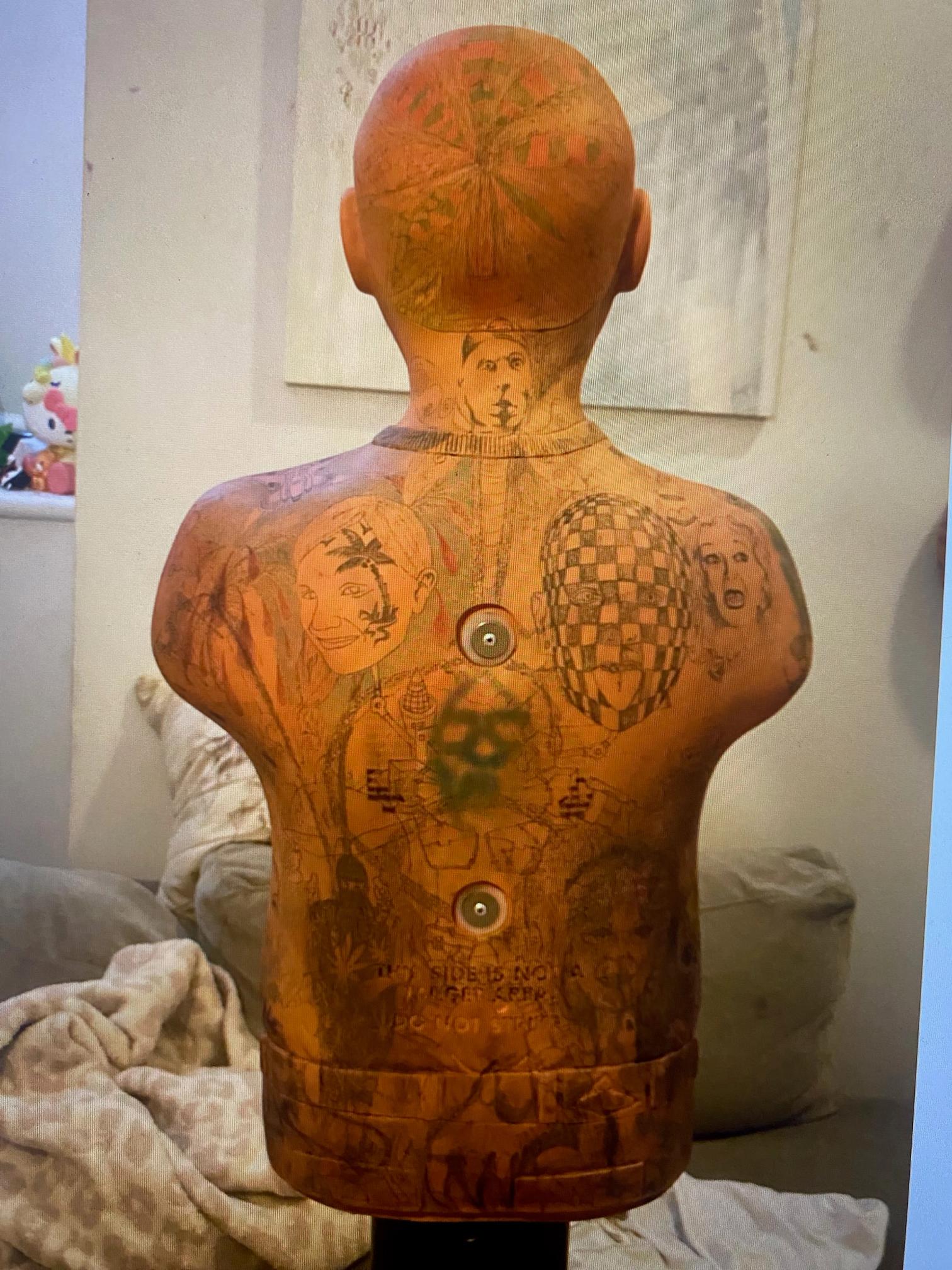 the back of a mannequin has a lot of tattoos on it