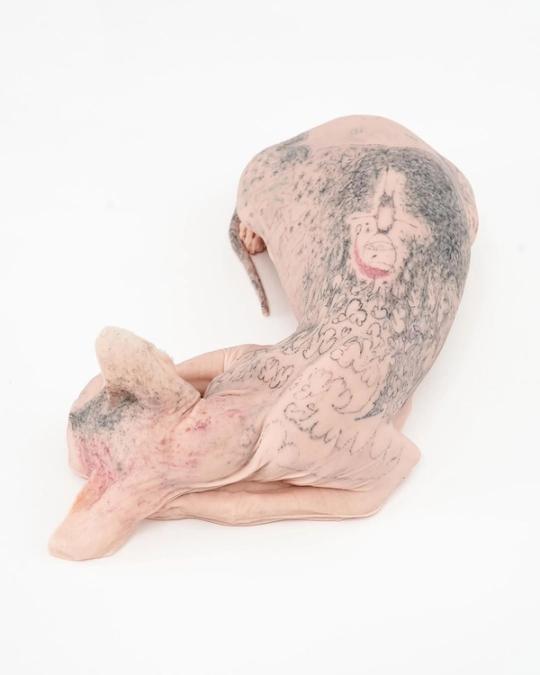 a statue of a cat with a tattoo on its back