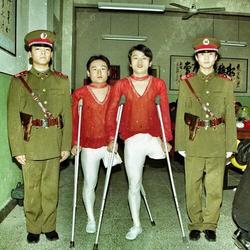 four men in military uniforms are standing next to each other with crutches