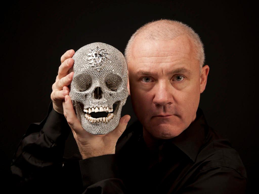 a man is holding a skull made of diamonds in his hands .