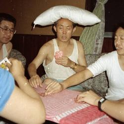 a man with a pillow on his head is playing cards