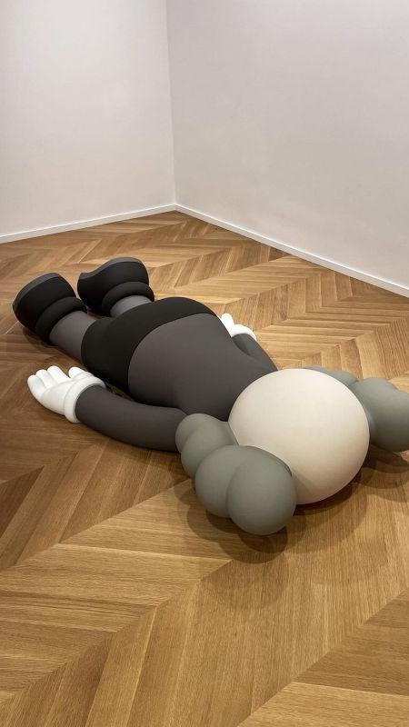 Kaws Sculpture laying facedown in gallery