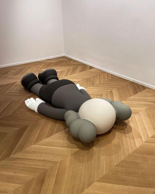 Kaws Sculpture laying facedown in gallery