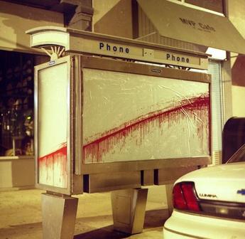 a white car is parked in front of a phone booth