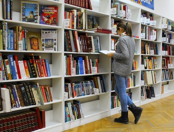 woman browsing bookshelves at a store or library woman browsing bookshelves at a store or library
