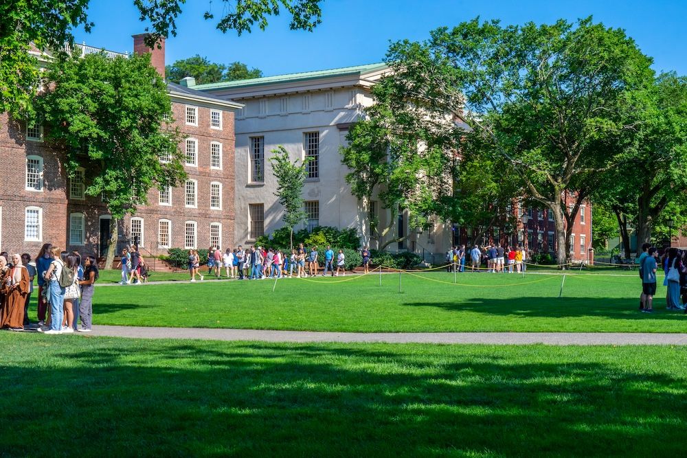 Students touring an outdoor college campus on a sunny day