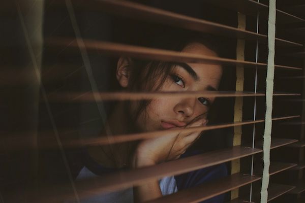 Girl looking out window due to college rejection. 