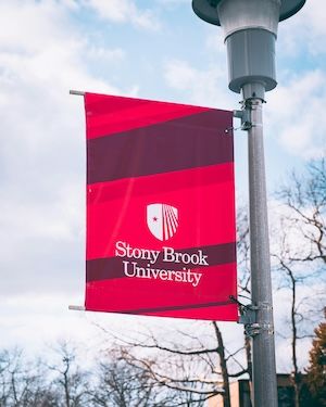 Stony Brook University logo on lamp post. Participate in Simons Summer Research Program. 