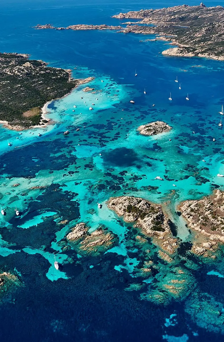 Aerial view of turquoise coves and anchored yachts in Sardinia