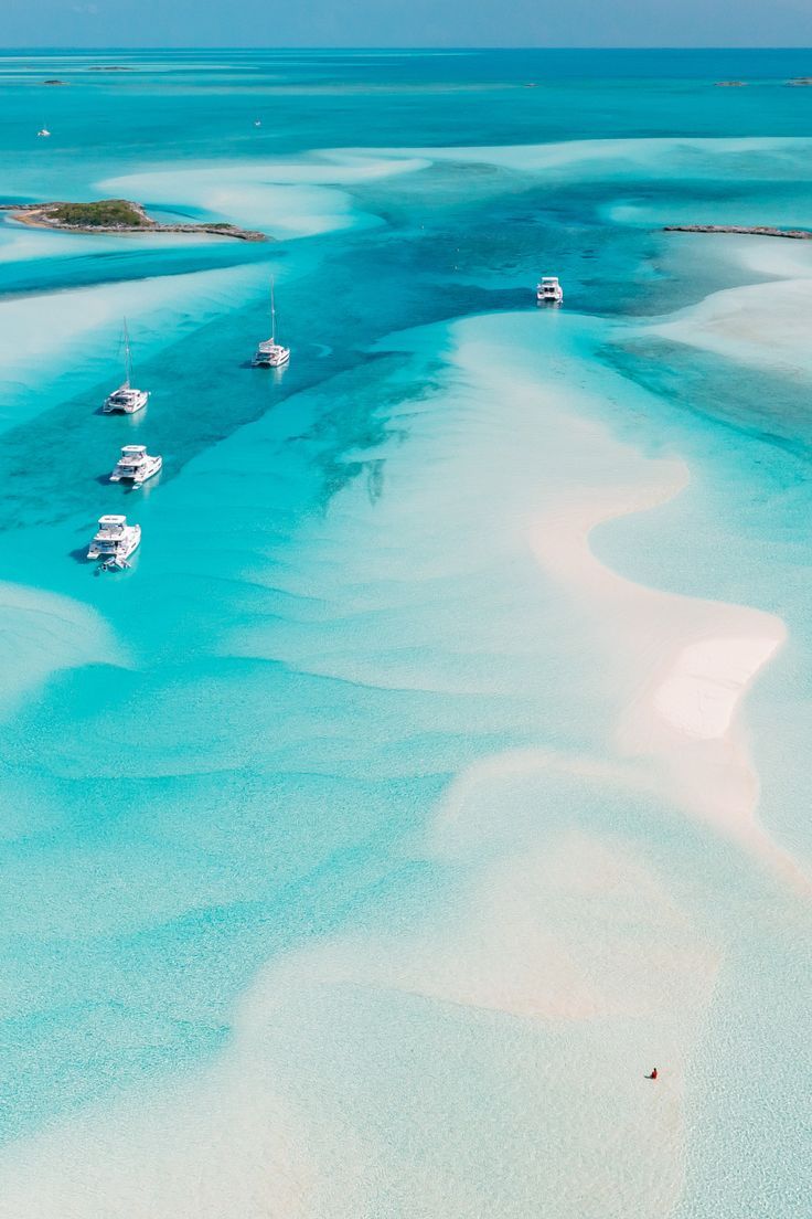 Yachts anchored in shallow turquoise waters in the Bahamas