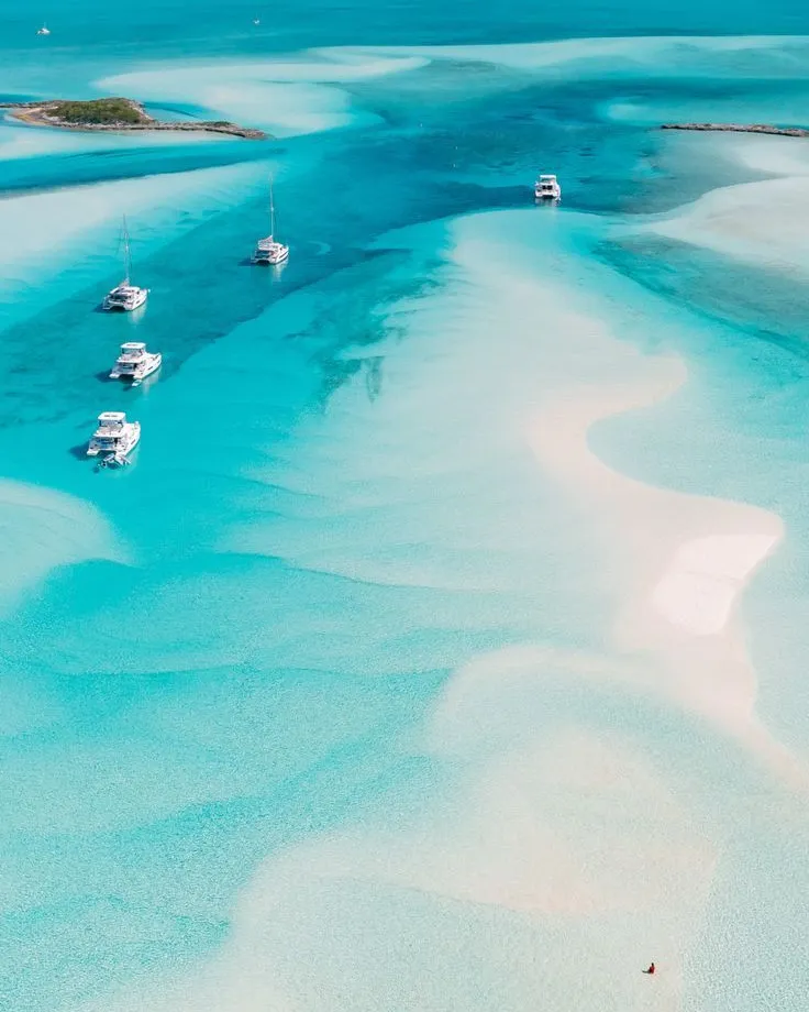 Yachts anchored in shallow turquoise waters in the Bahamas