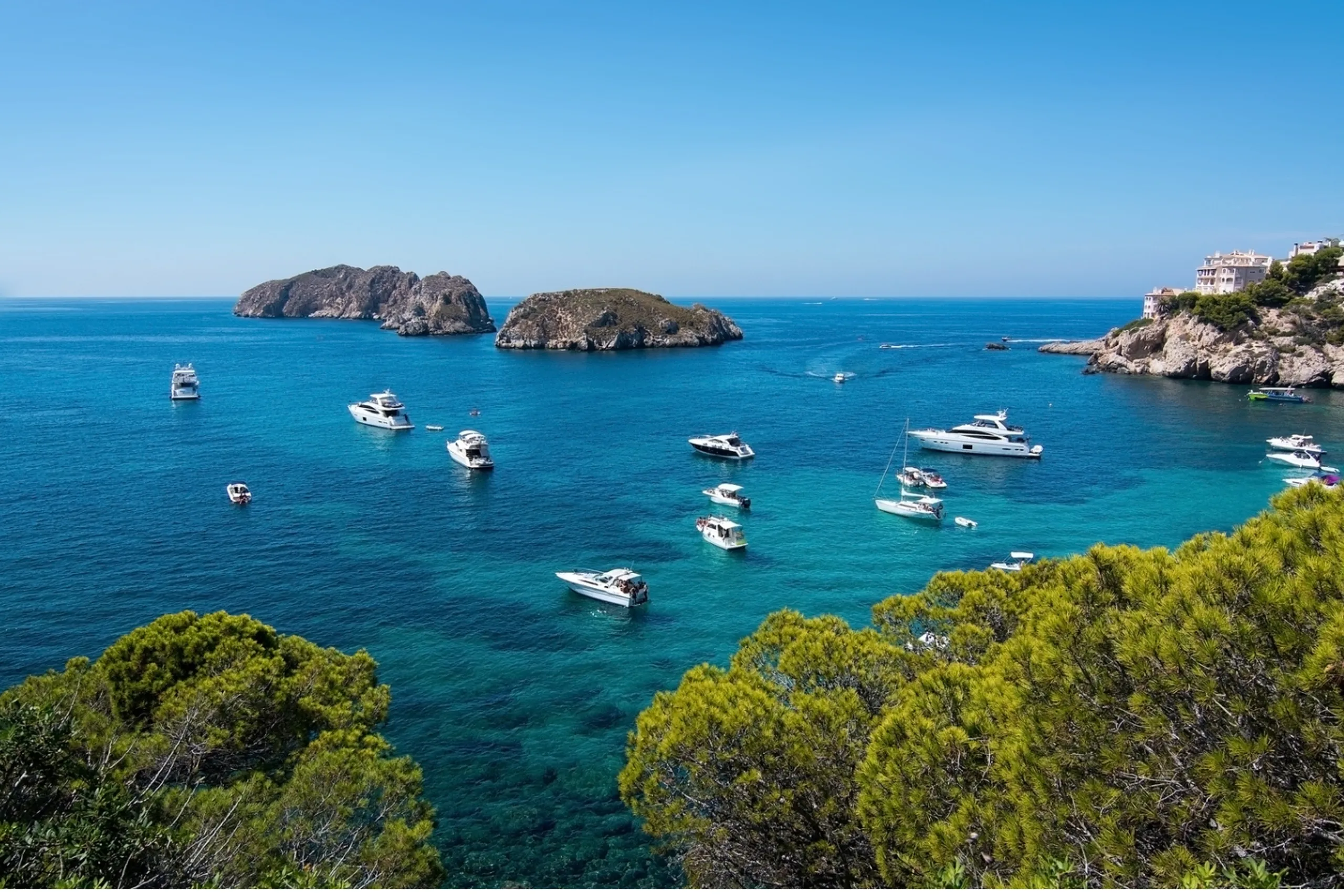 Boats anchored in a clear Mediterranean cove in Mallorca