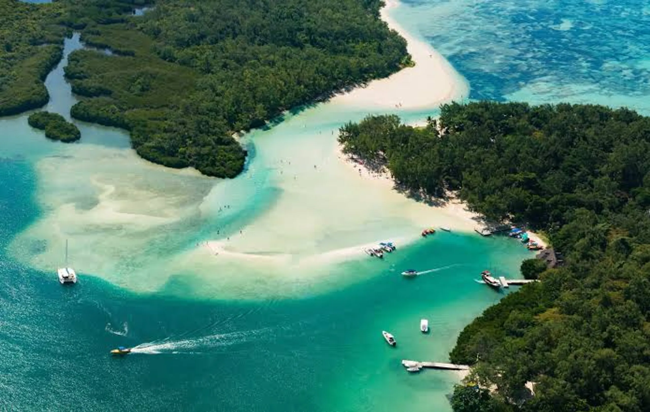 Boats anchored in a turquoise lagoon near a white sand beach in Mauritius