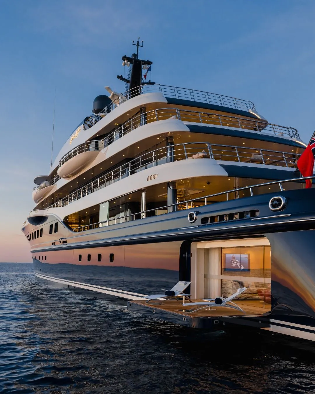Luxury superyacht exterior with fold-out balcony at sunset
