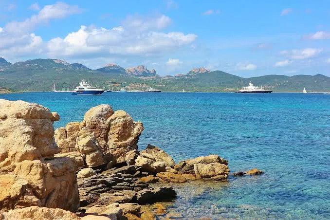 Yachts anchored off the rocky coastline of Porto Cervo in Sardinia