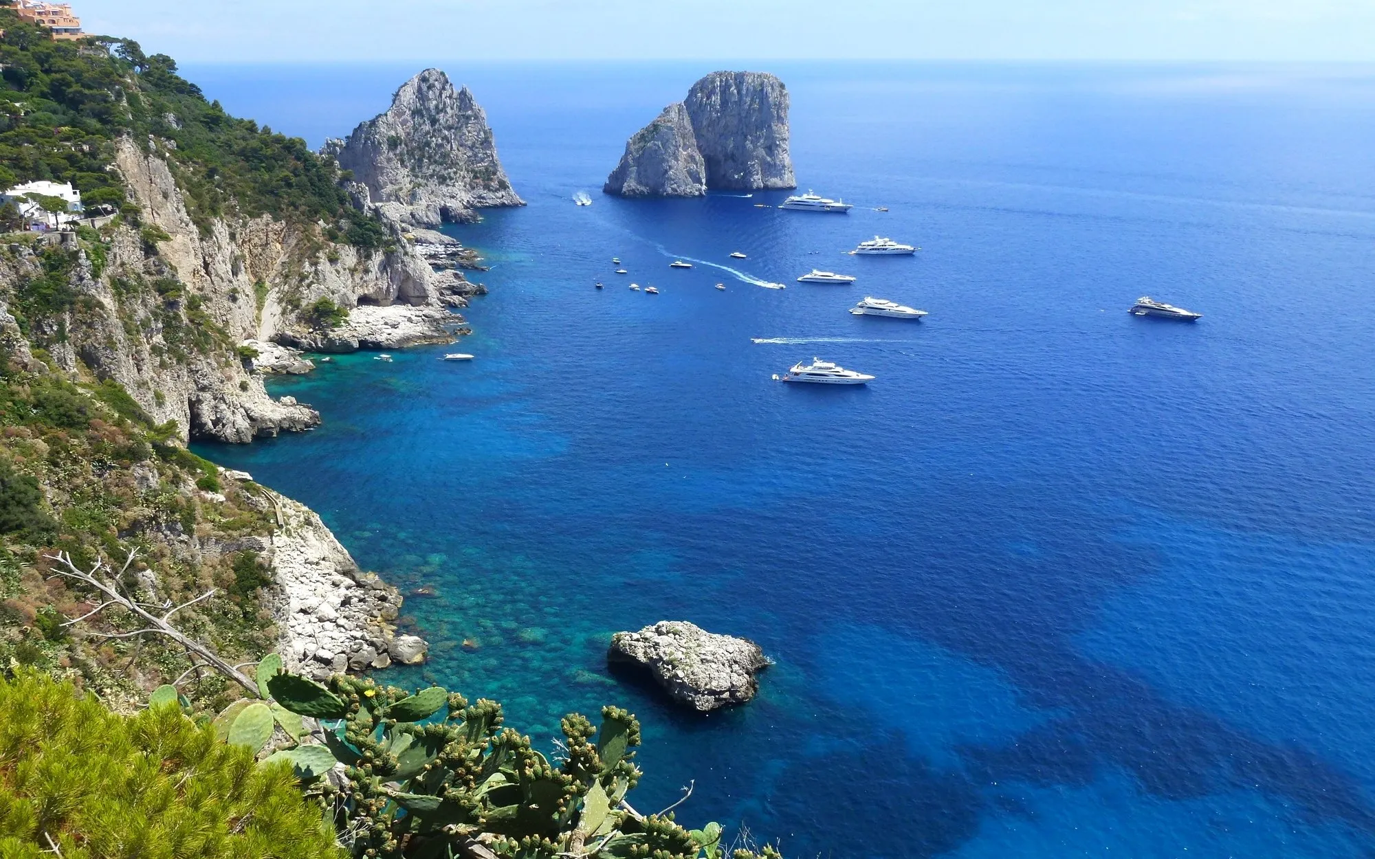 Yachts cruising near the Faraglioni rocks off Capri, Italy