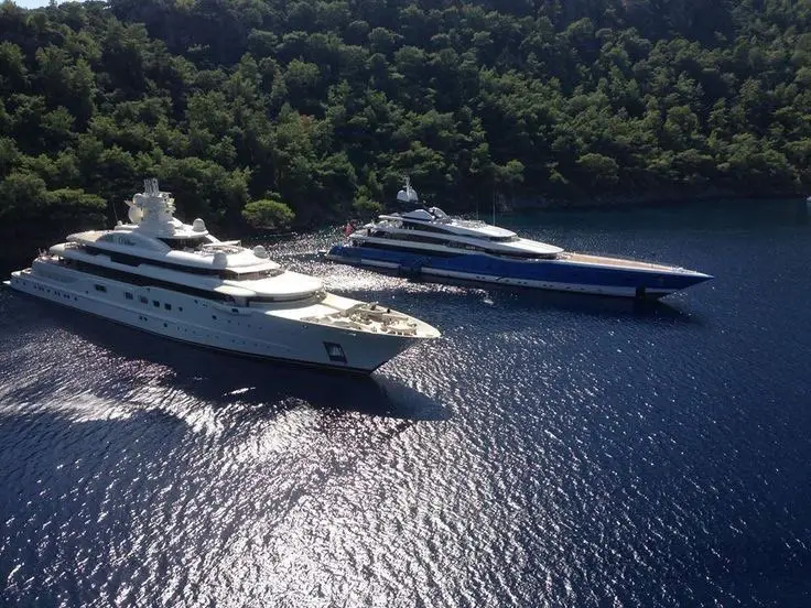 Private superyachts anchored in a secluded Mediterranean cove